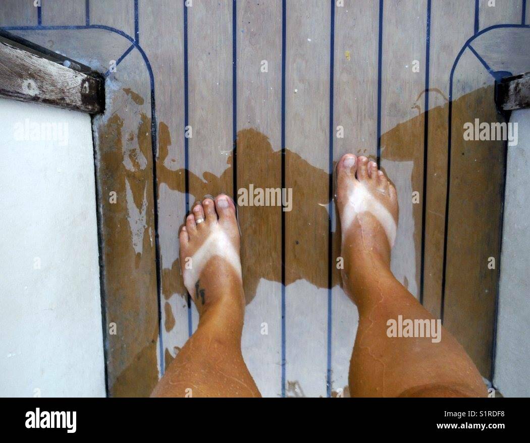 In piedi su un ponte di barche con linee abbronzanti flip flop - Immagine stock catturata con smartphone