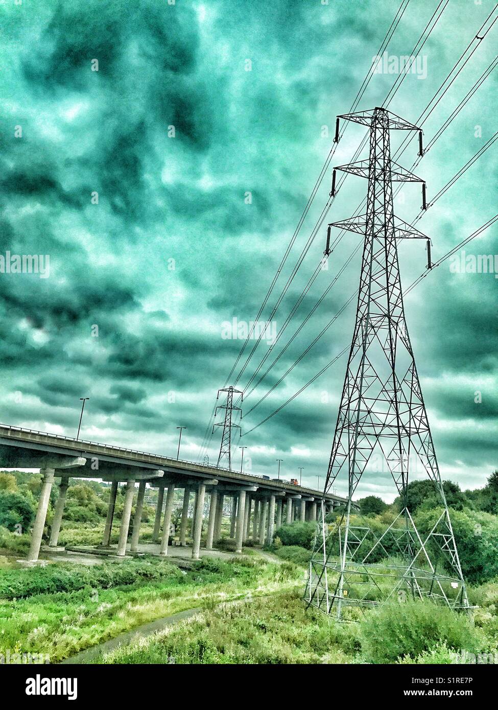 Tralicci elettrici con cavi che attraversano un tratto rialzato dell'autostrada M6 - Immagine stock catturata con smartphone