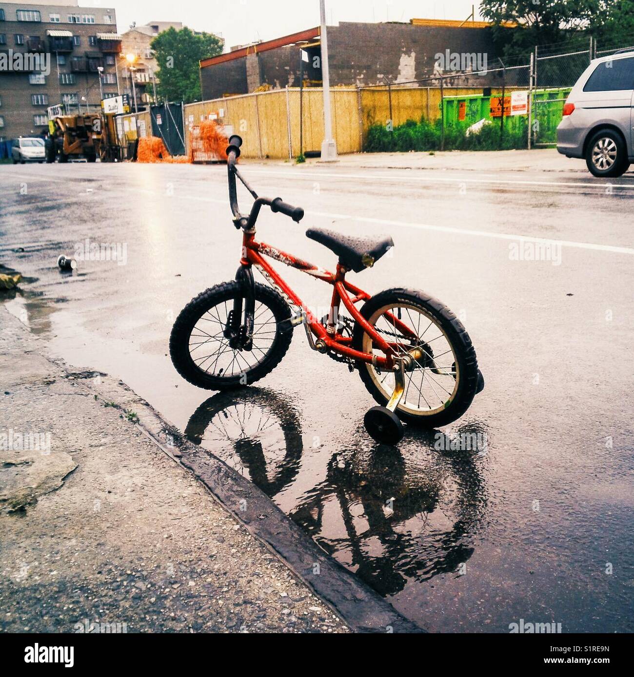 Bambini in bicicletta la strada a una piovosa mattinata Foto Stock