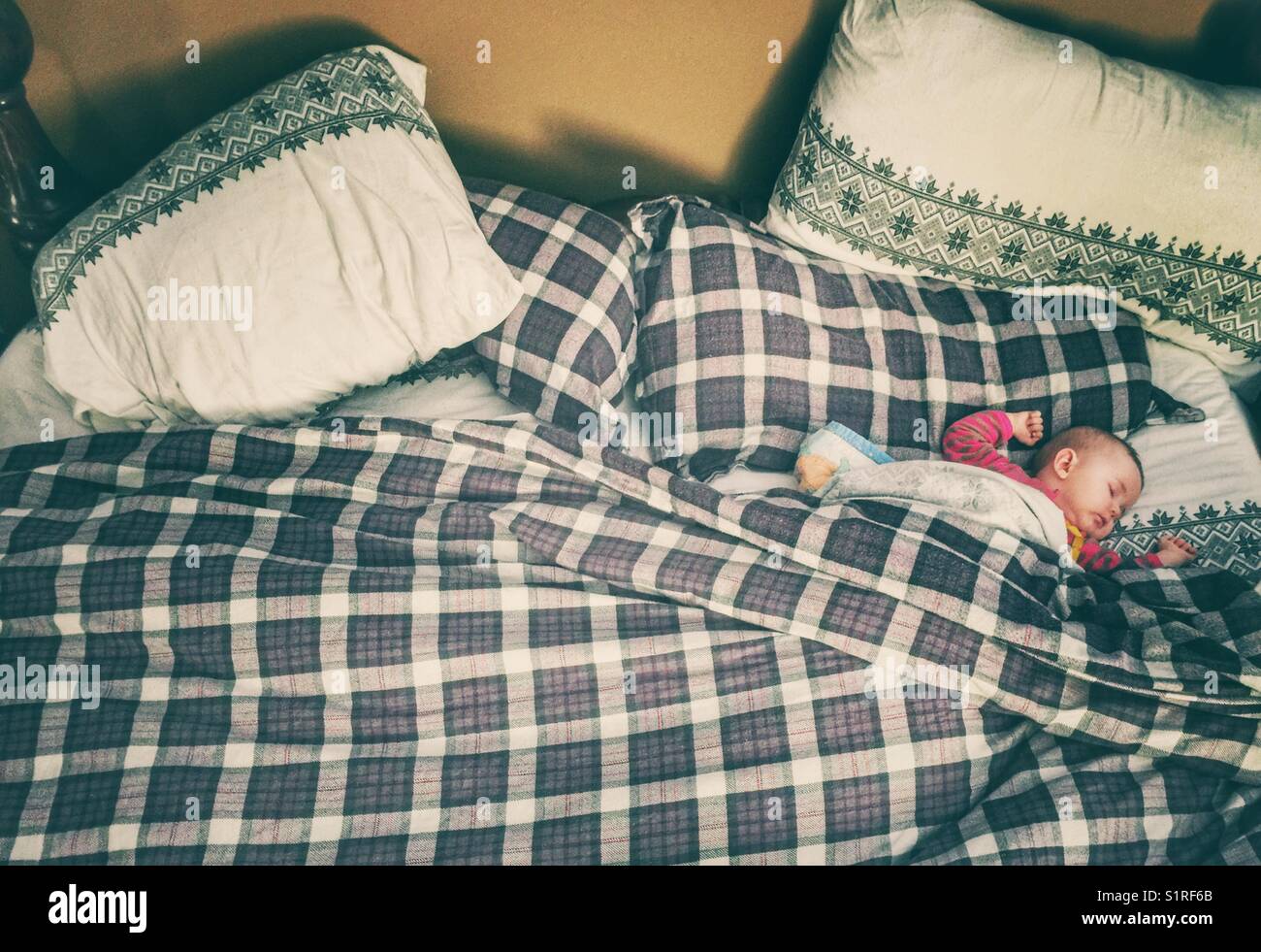 Neonato che dorme nel letto king size dei genitori - Immagine stock catturata con smartphone