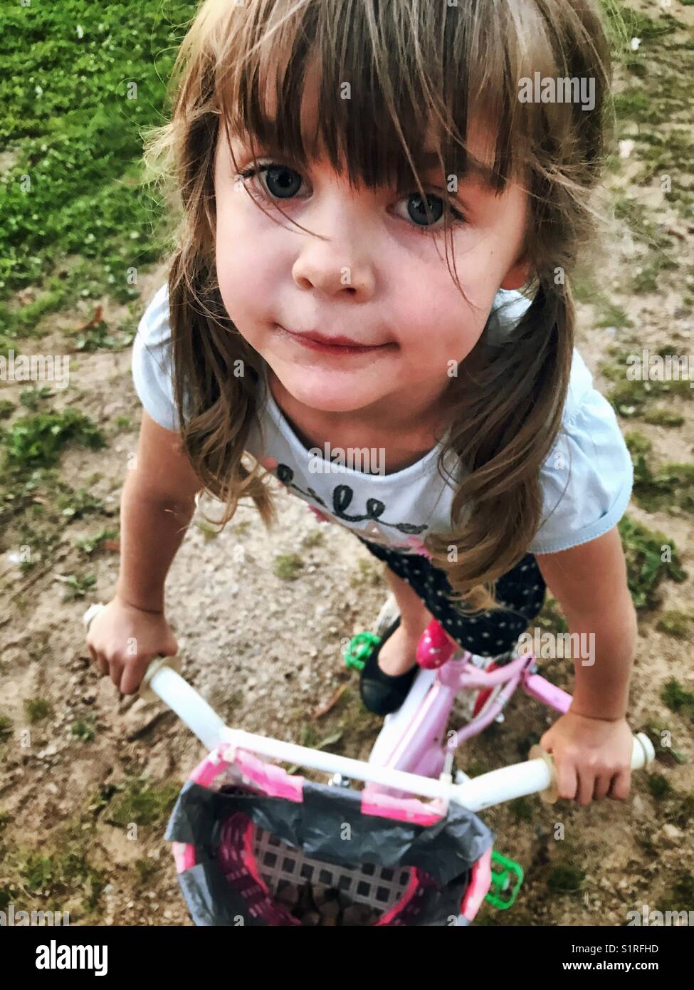 Ragazza con pig-tail permanente sulla bicicletta Foto Stock