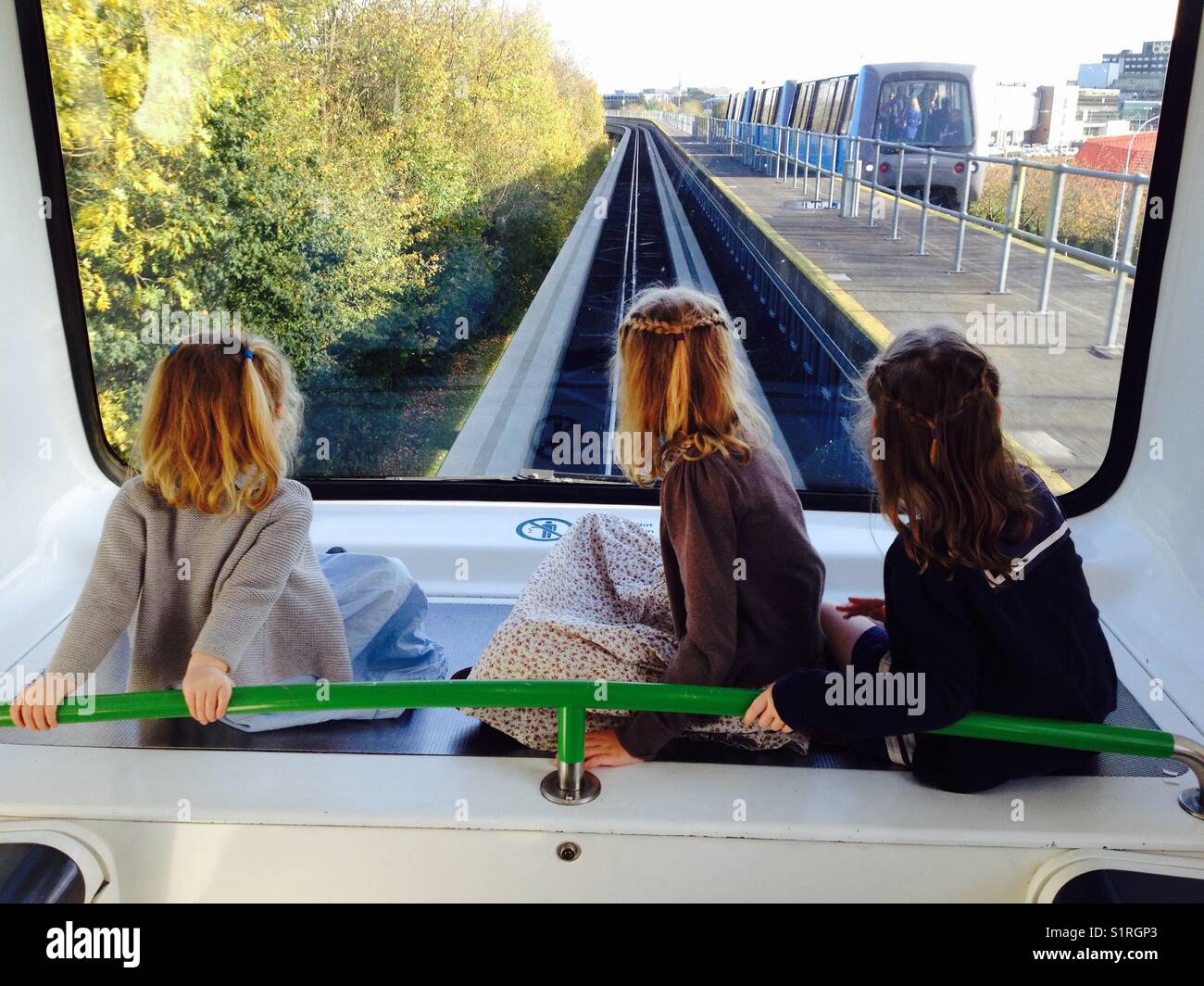 Le tre sorelle / i ragazzi/ragazze corsa sull'aeroporto di Gatwick in treno navetta tra il terminal Nord e il terminal sud. Foto Stock