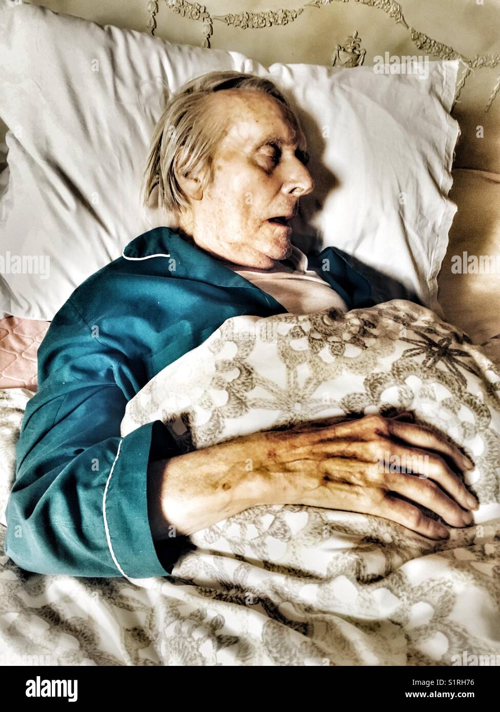 Uno stato di malessere anziano uomo dorme nel letto Foto Stock