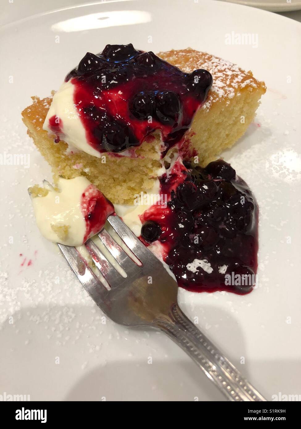 Dessert delizioso - torta al limone con coulis di frutta e panna - Immagine stock catturata con smartphone