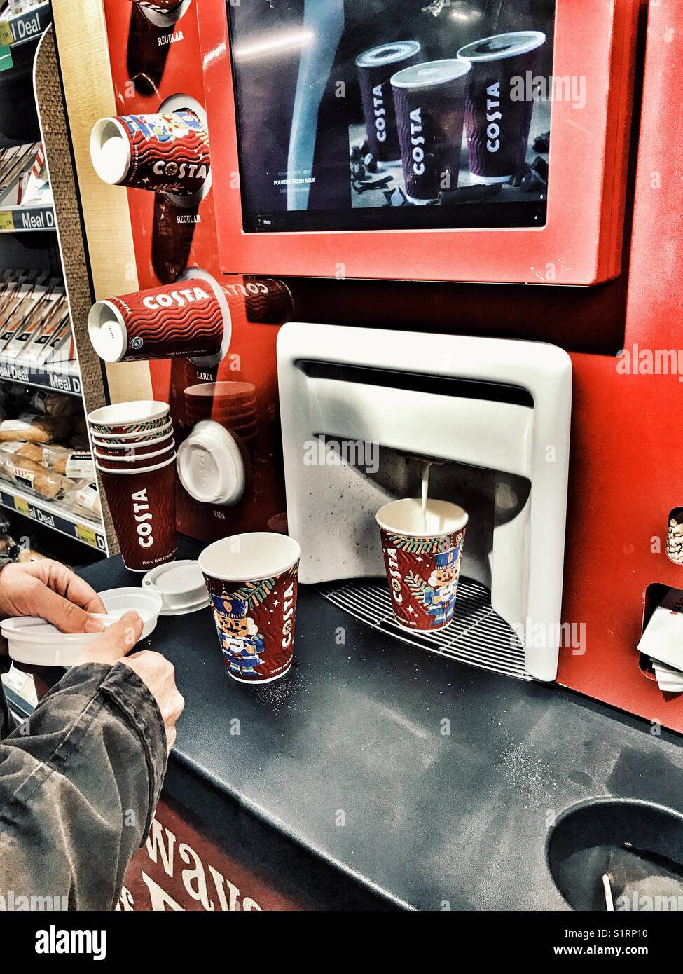 Donna che utilizza un caffè Costa self service distributore automatico in un supermercato in un campus universitario. - Immagine stock catturata con smartphone