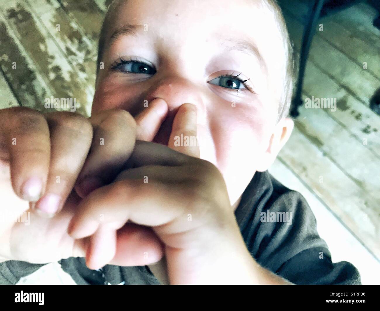 Immagine del giovane ragazzo sticking dita nelle sue narici Foto Stock