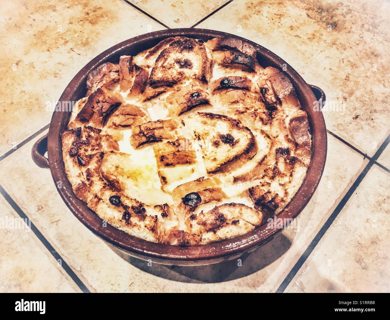 Pane fatto in casa e budino di burro in un piatto di terracotta - Immagine stock catturata con smartphone