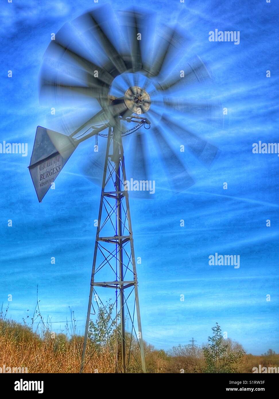 Mulino a vento con rotori in movimento contro un cielo blu forte - Immagine stock catturata con smartphone