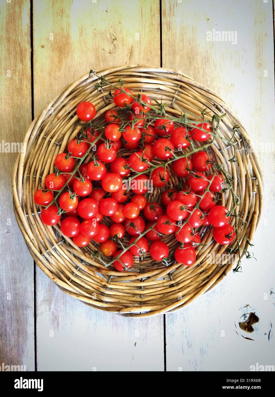 Pomodori ciliegini su un vassoio di vimini - Immagine stock catturata con smartphone