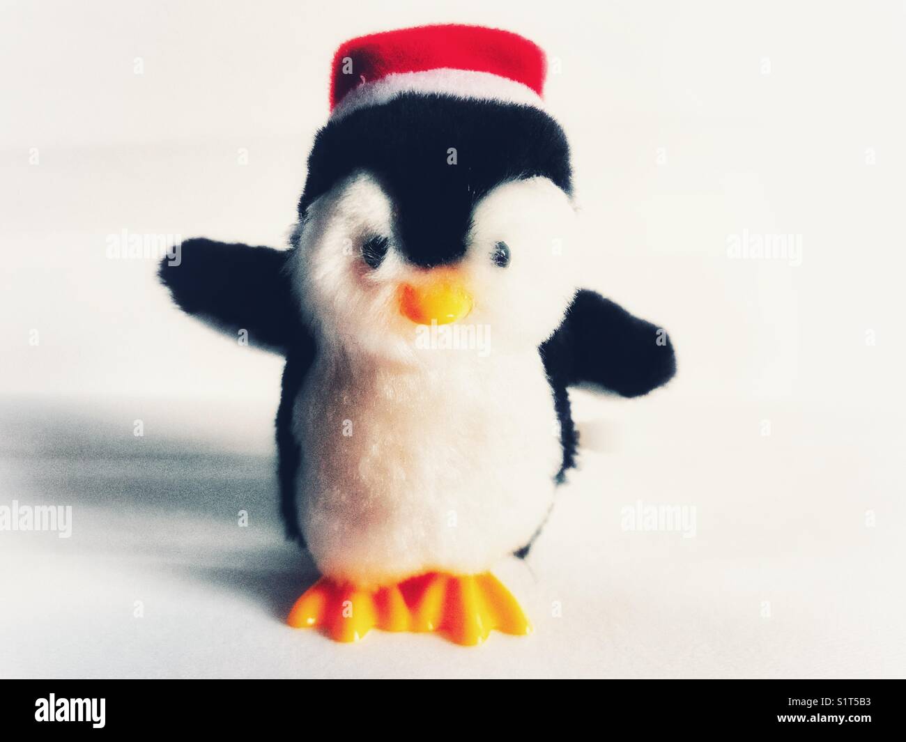 Decorazione di natale, vento su toy penguin su bianco Foto Stock