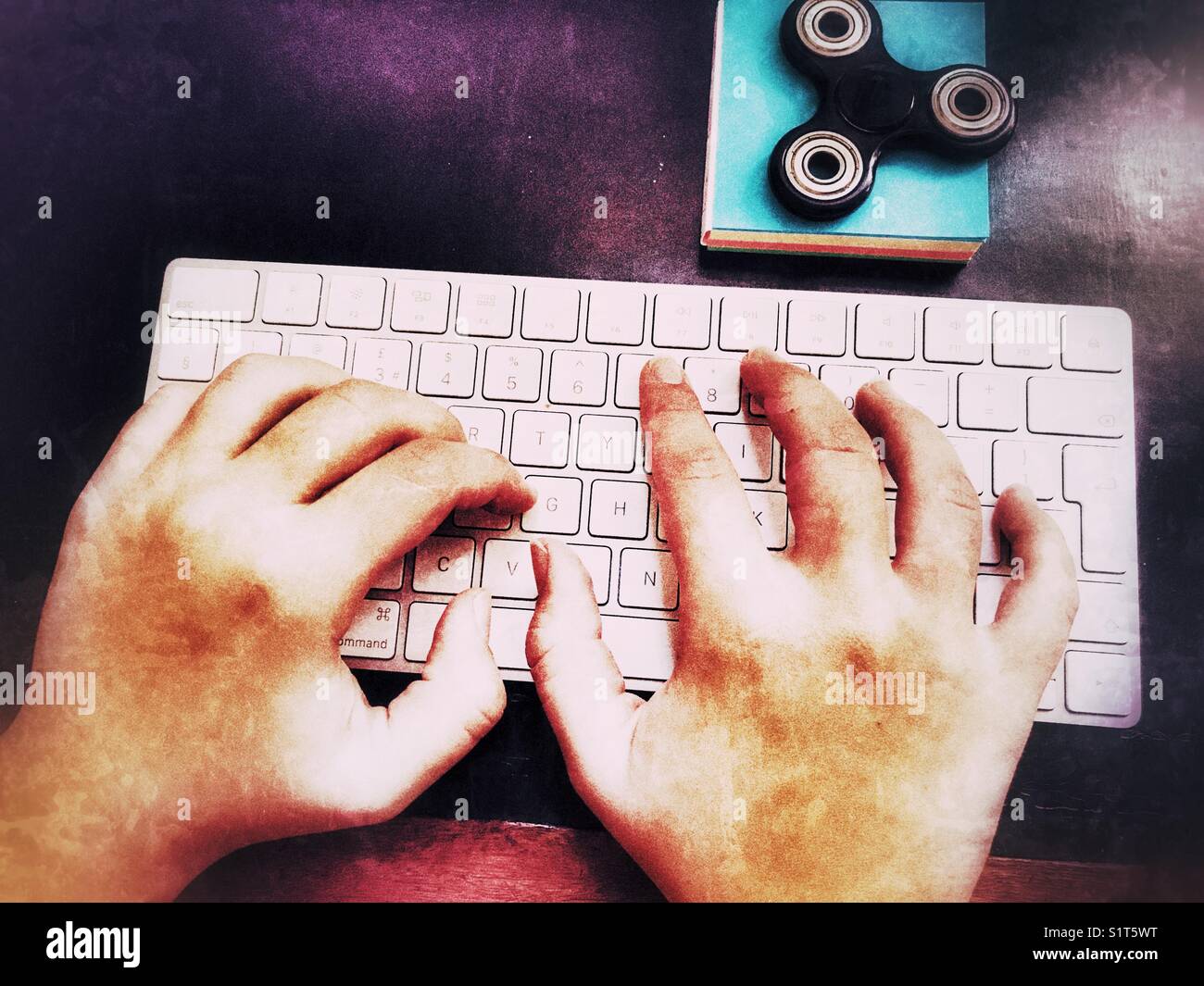 Pov prospettiva personale, donna millenaria le mani sulla tastiera del computer con un agitano: spinner su un blocco note di blu. Foto Stock