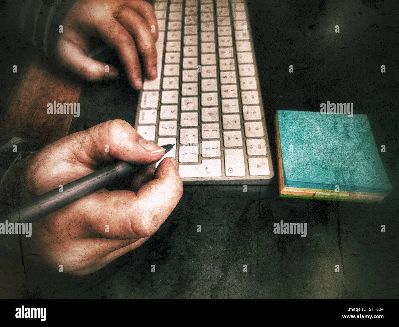 Donna millenaria con penna in mano, tastiera per computer e blocco note sulla scrivania Foto Stock