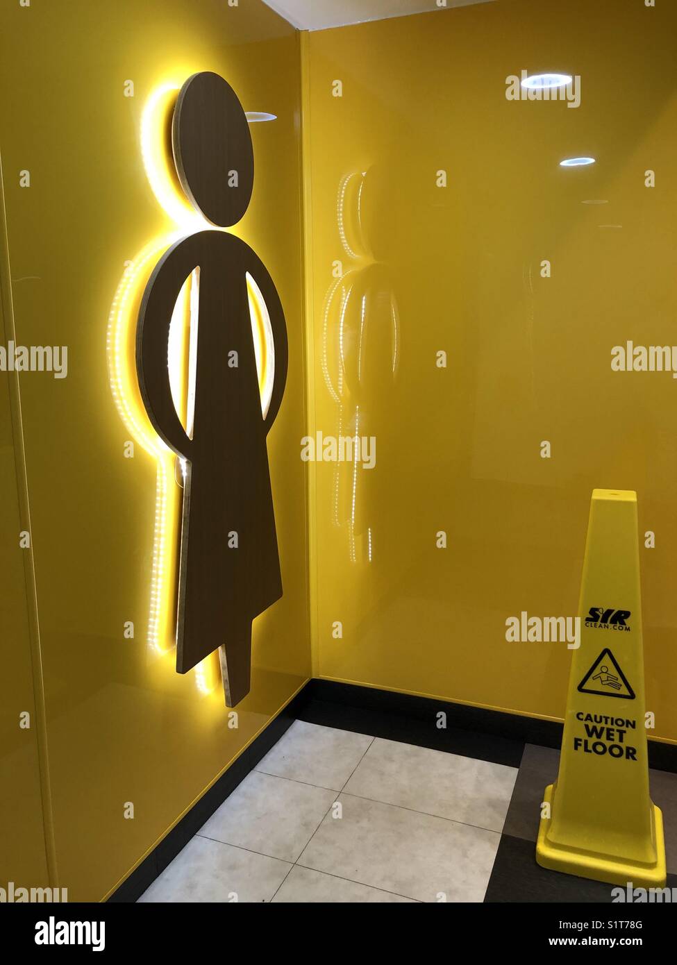 Ingresso a un pubblico Ladies toilet con un cono per pavimento bagnato Foto Stock