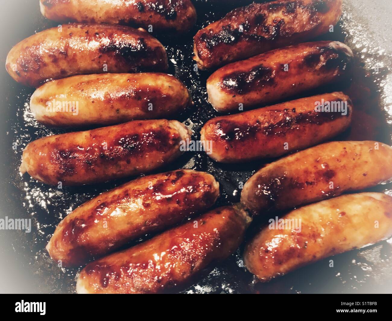 Cuocere le salsicce in una padella Foto Stock