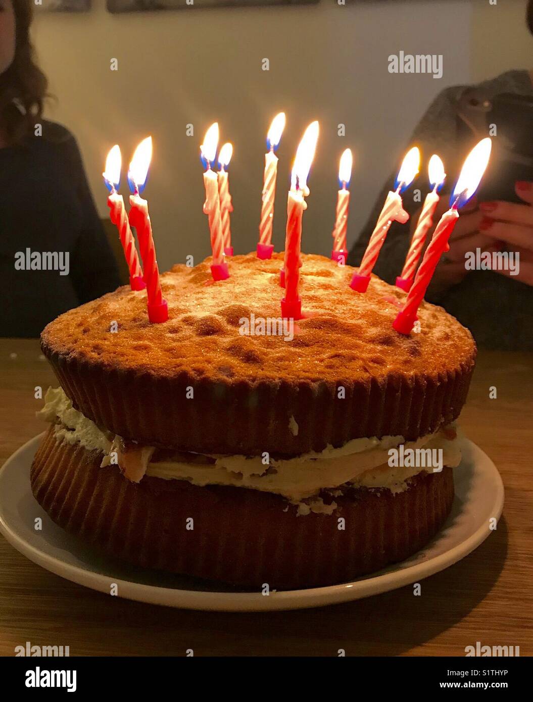 In casa torta di compleanno con candele accese Foto Stock