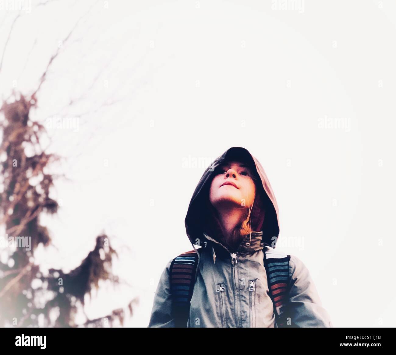Ragazza che guarda il cielo in una mattinata ricoperta, nebbiosa, fredda - Immagine stock catturata con smartphone