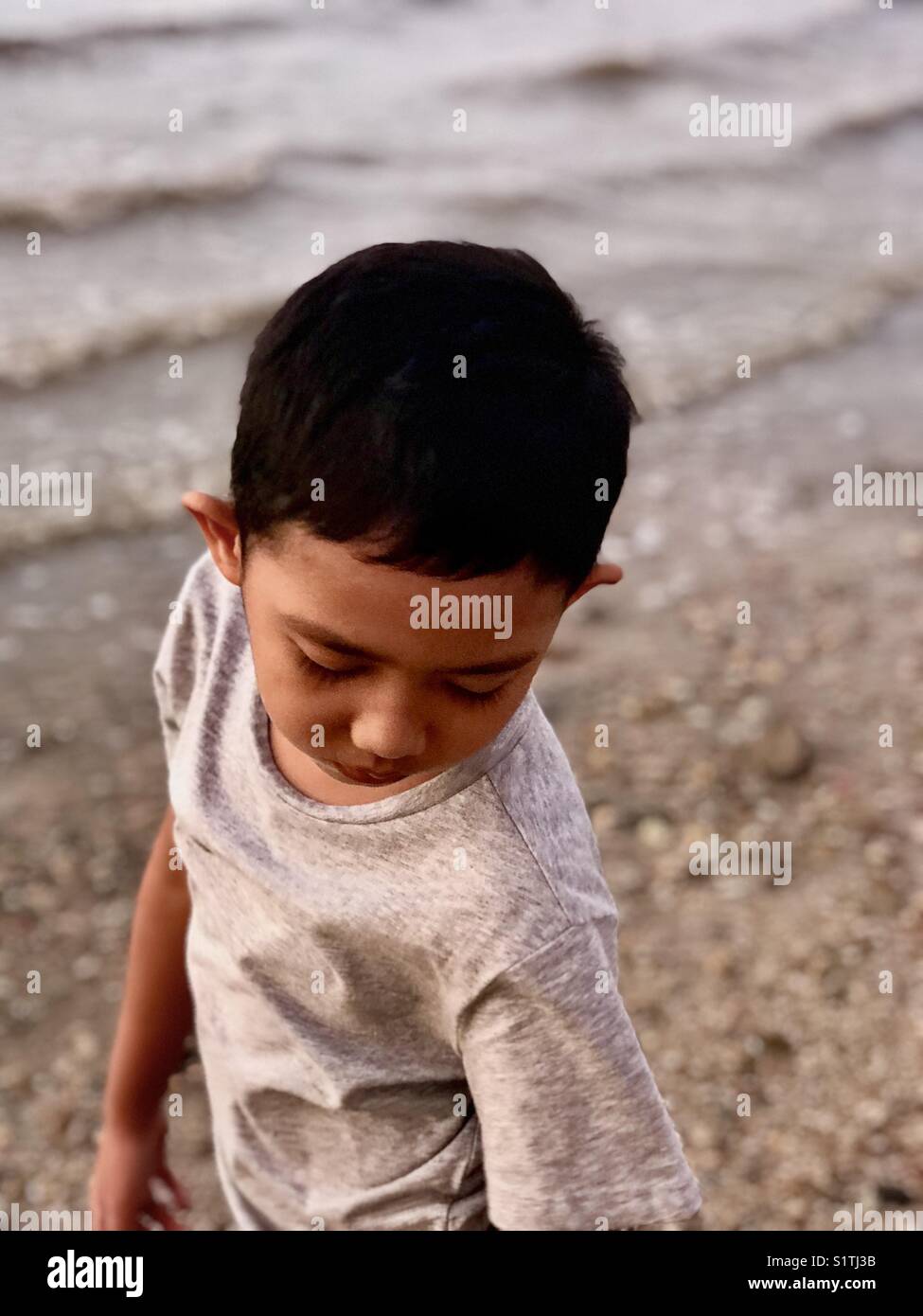 Un ragazzo asiatico giocando sulla spiaggia. Foto Stock