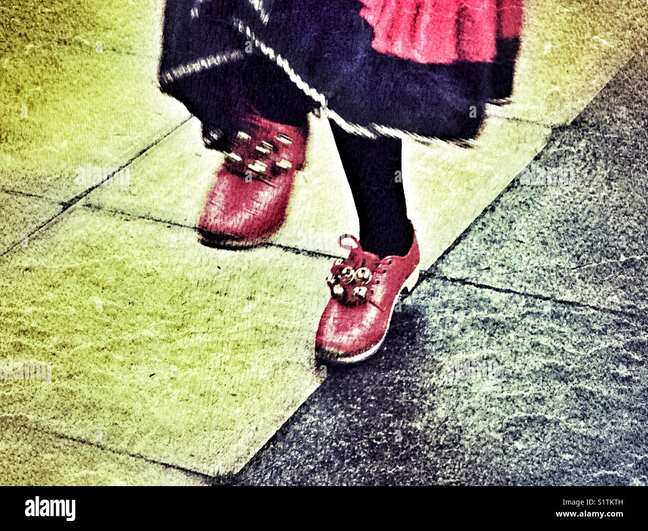 Intasare dancing, un tradizionale English Folk Dance, dettaglio di gambe & rosso zoccoli con campane. Prestazioni all'aperto a Sherborne, Dorset, Inghilterra, - Immagine stock catturata con smartphone