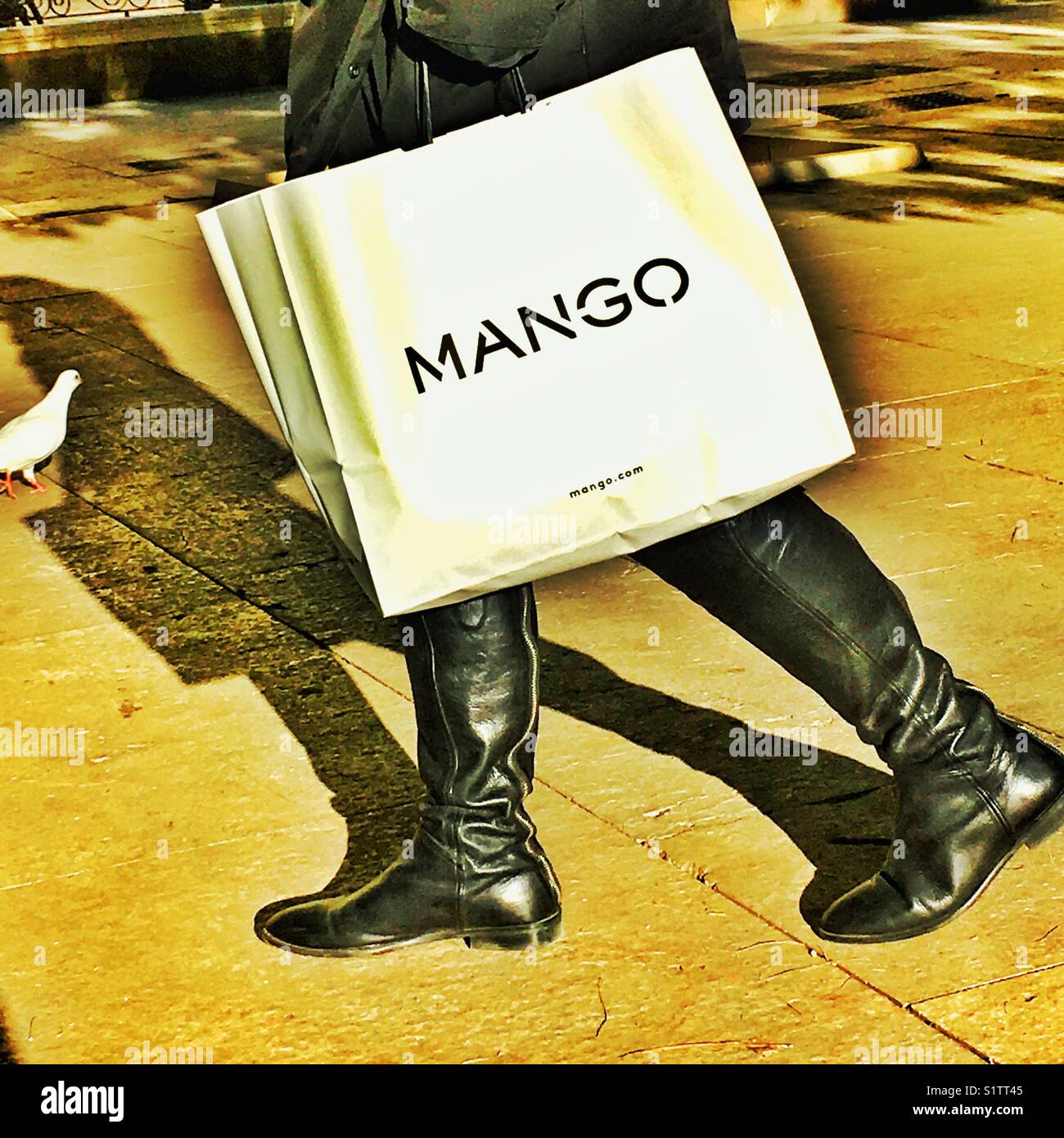 Una donna con una borsa della spesa Mango per strada Foto Stock