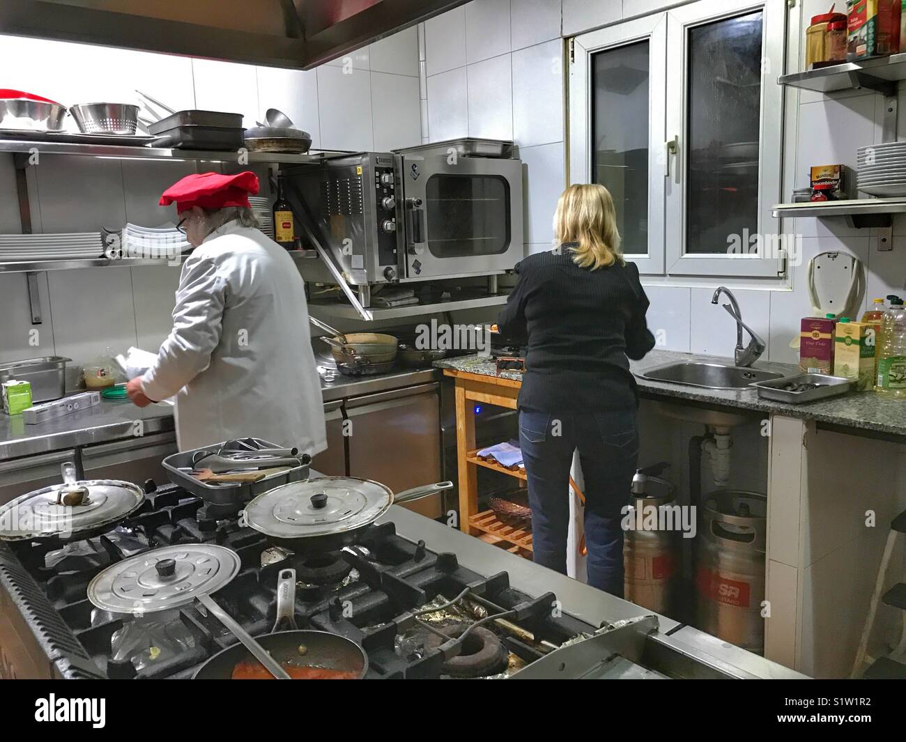 Chef e assistente alla preparazione dei pasti in una cucina commerciale Foto Stock