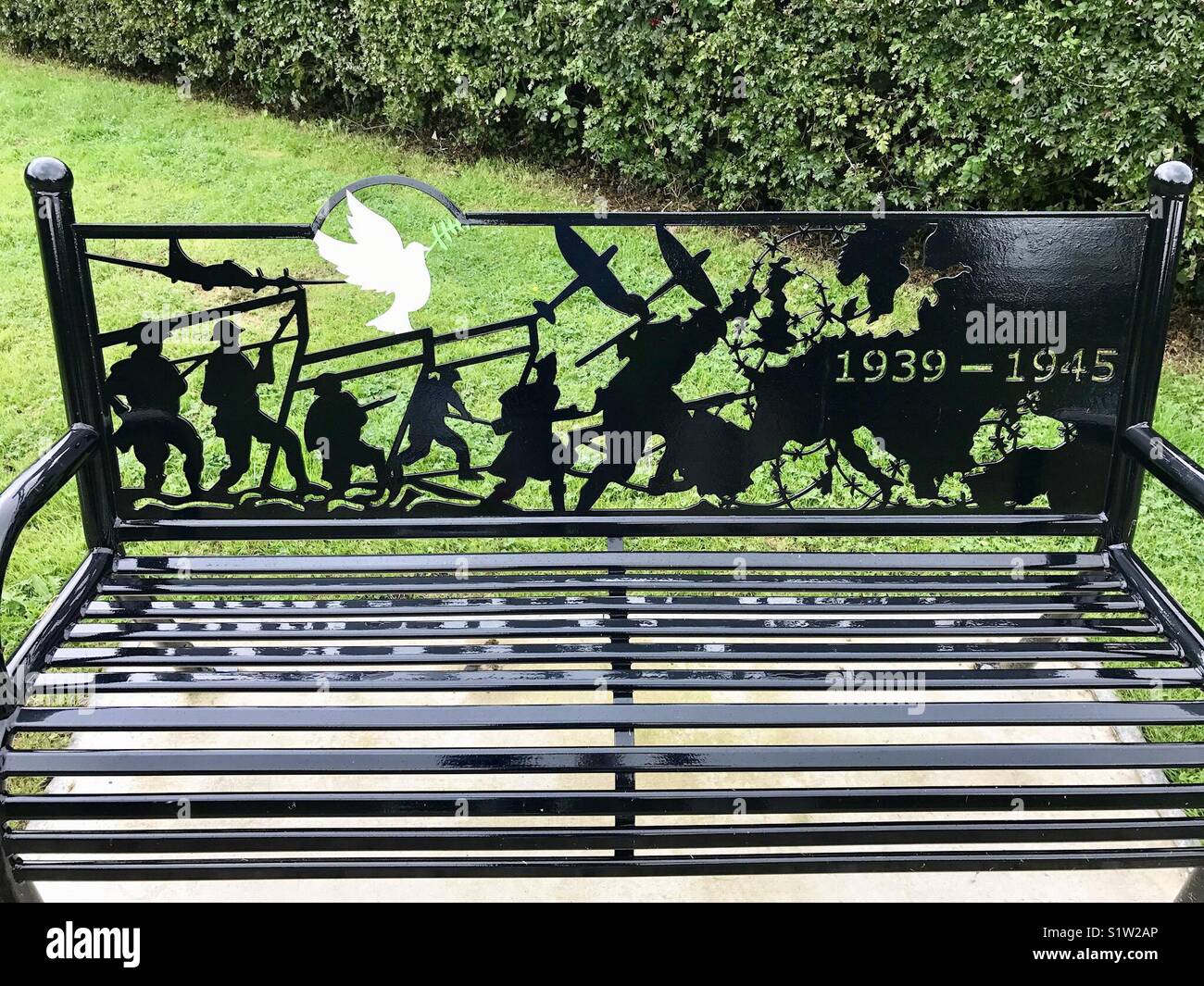 Lamiera design che commemora la II Guerra Mondiale su un sedile nel memorial garden Foto Stock