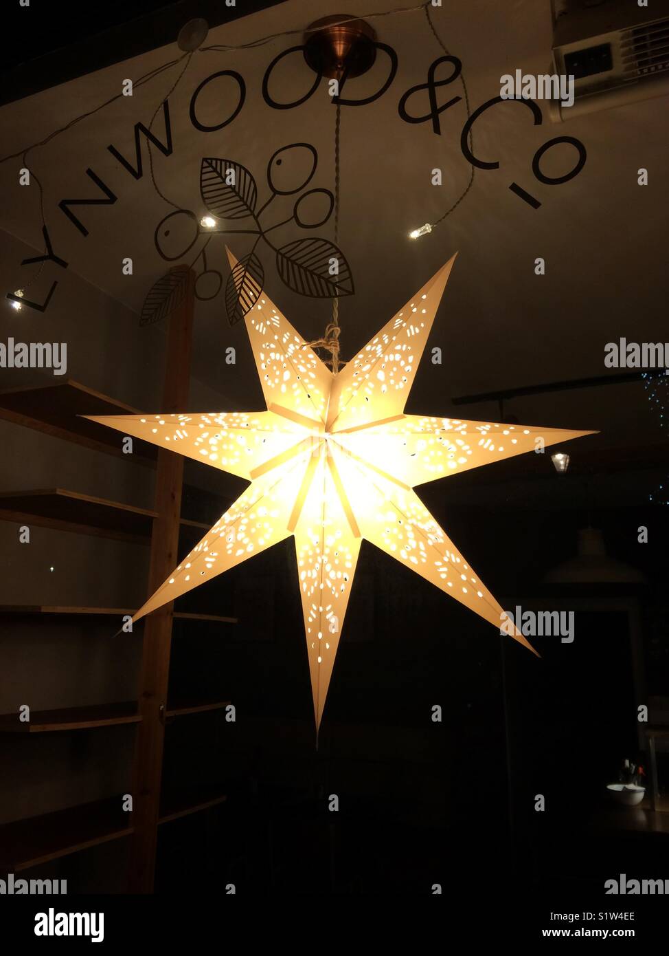 Stella di natale decorazione appesi nella vetrina di un caffè in un Cotswold town, REGNO UNITO Foto Stock