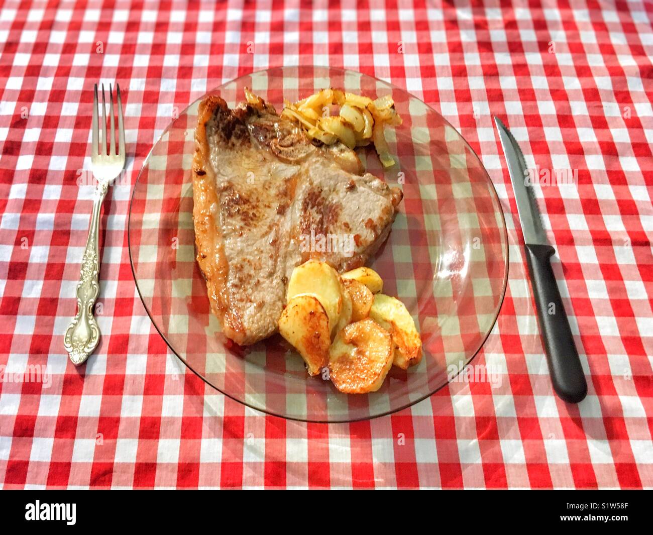 T-bone steak con patate fritte e oignons caramellati. - Immagine stock catturata con smartphone