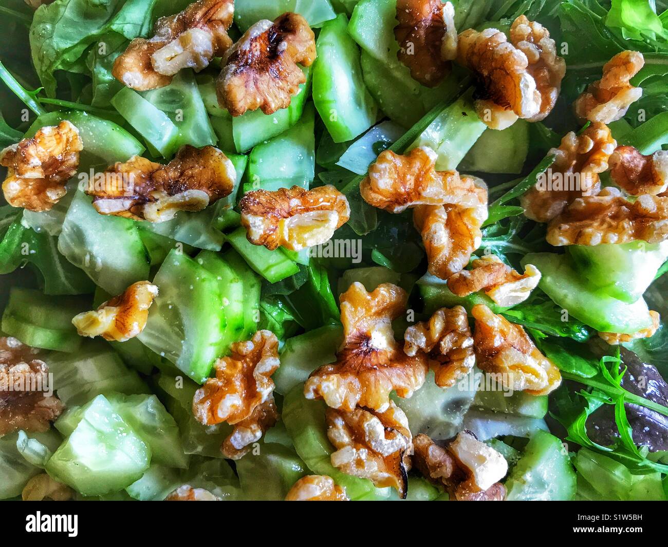Fresca insalata verde con un misto di foglie, cetriolo e noci. Foto Stock