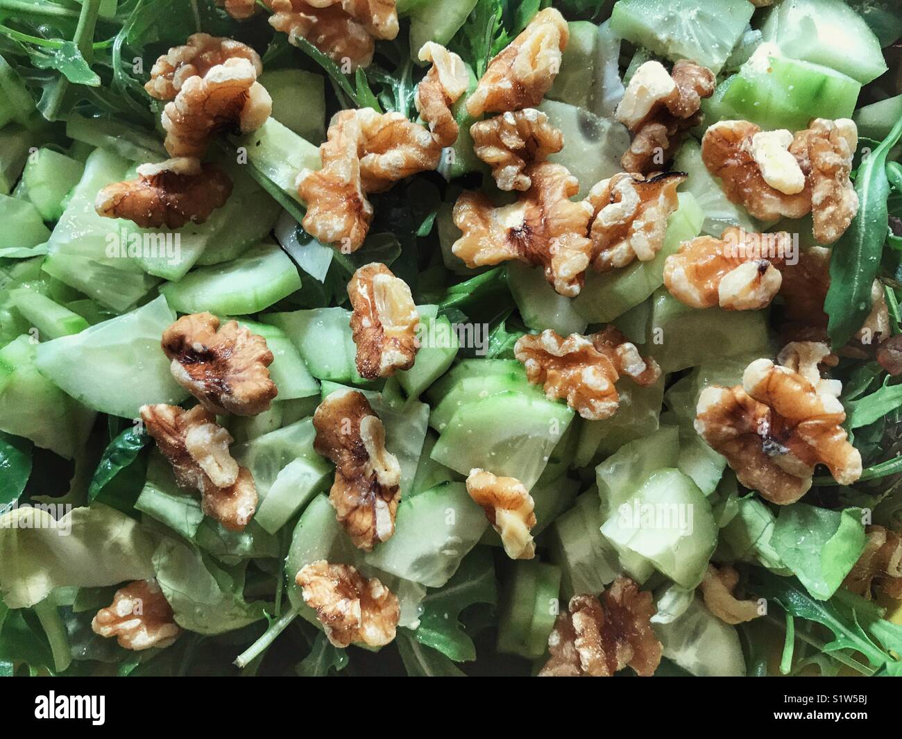 Fresca insalata verde con un misto di foglie, cetriolo e noci Foto Stock