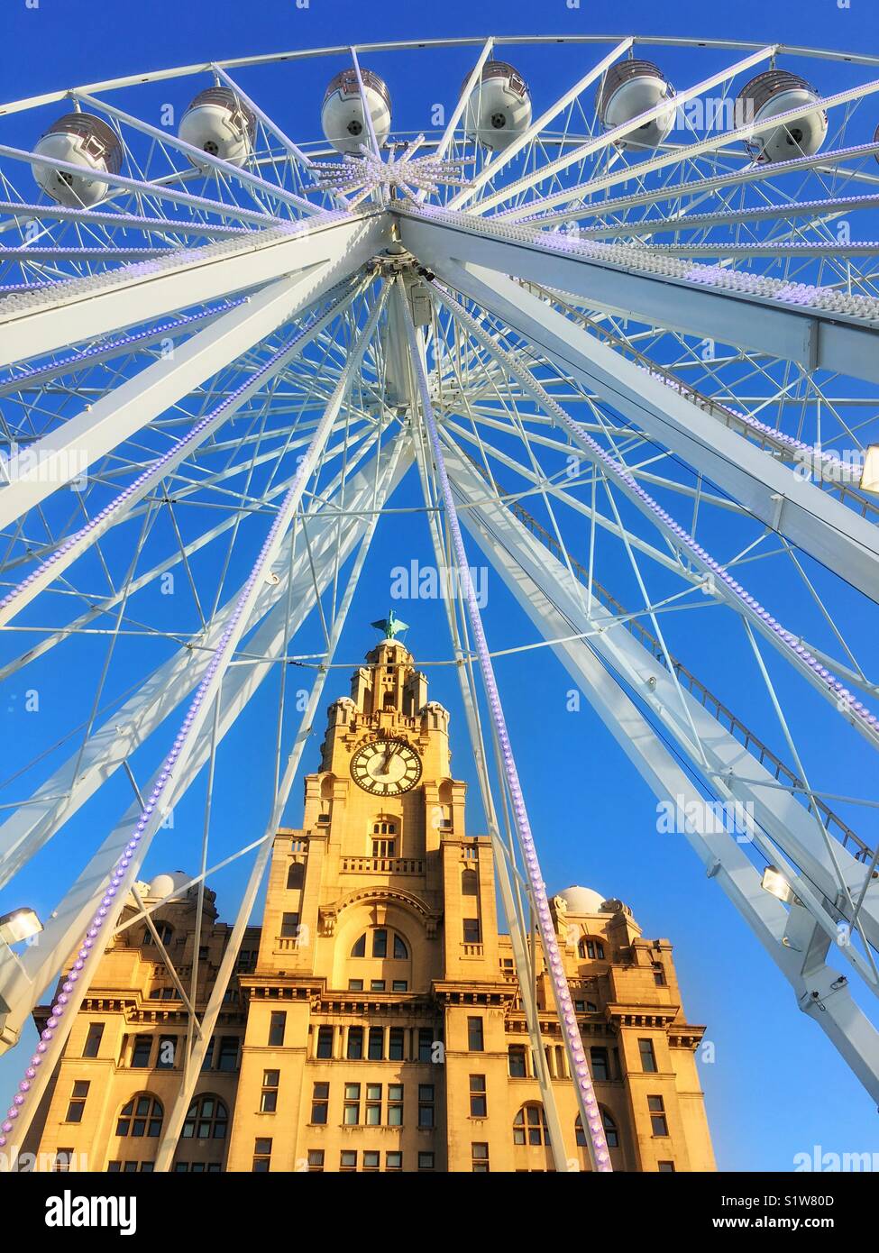 Royal Liver Building in Liverpool visto attraverso una ruota gigante contro un cielo blu Foto Stock