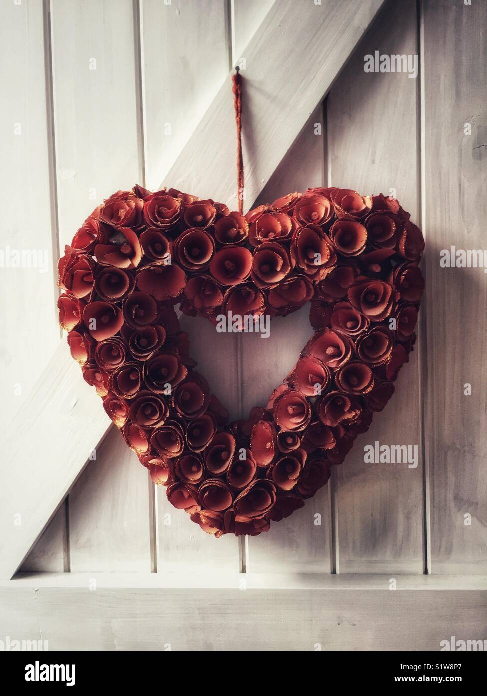 Cuore di fiori. Amore Rosso forma di cuore formato da fiori. Amore e romanticismo o simbolo di San Valentino. Foto Stock