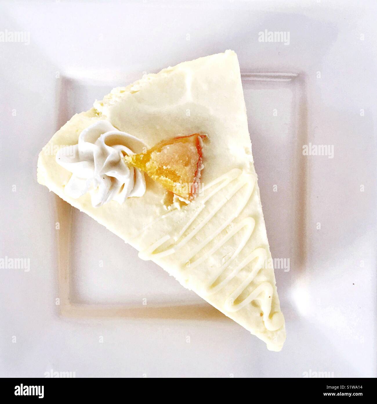 Una fetta di torta su un quadrato bianco piastra. Fotografato dal di sopra. - Immagine stock catturata con smartphone