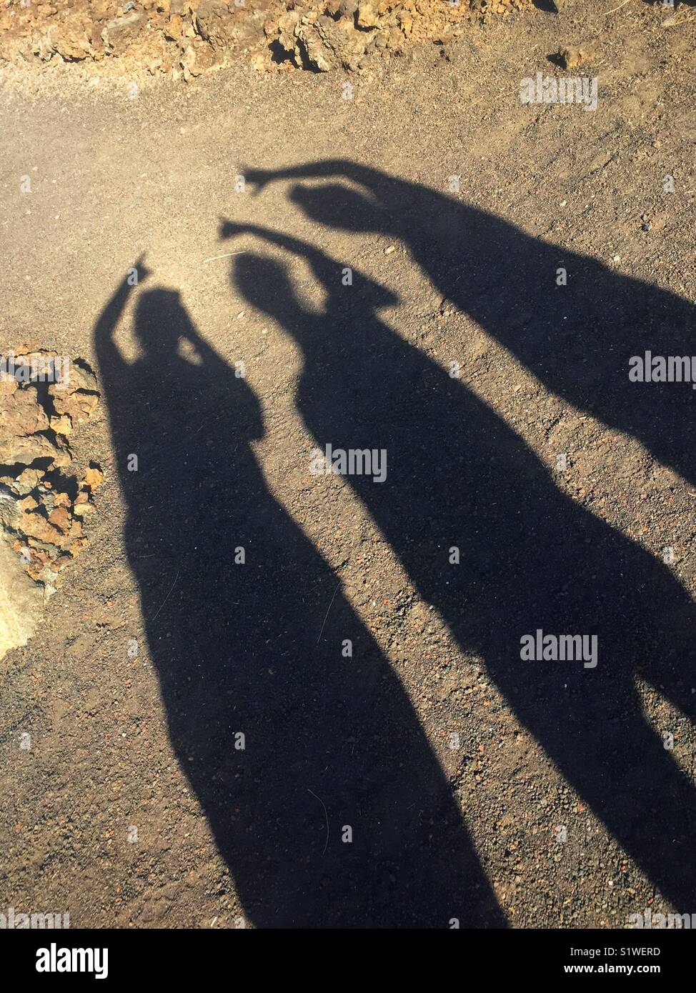 Tre le ombre delle persone dando la hang gesto allentati Foto Stock