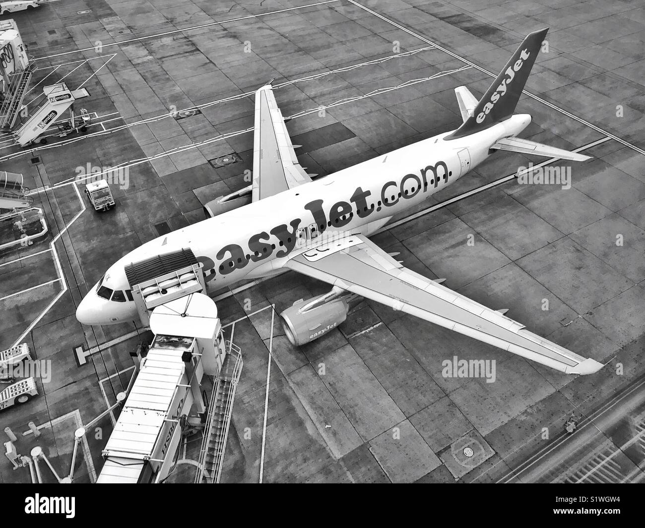 Un'immagine monocromatica di una vista aerea guardando in giù su un EasyJet Airbus in quanto si trova sulla pista di un aeroporto gate di partenza. Credito foto - © COLIN HOSKINS. - Immagine stock catturata con smartphone