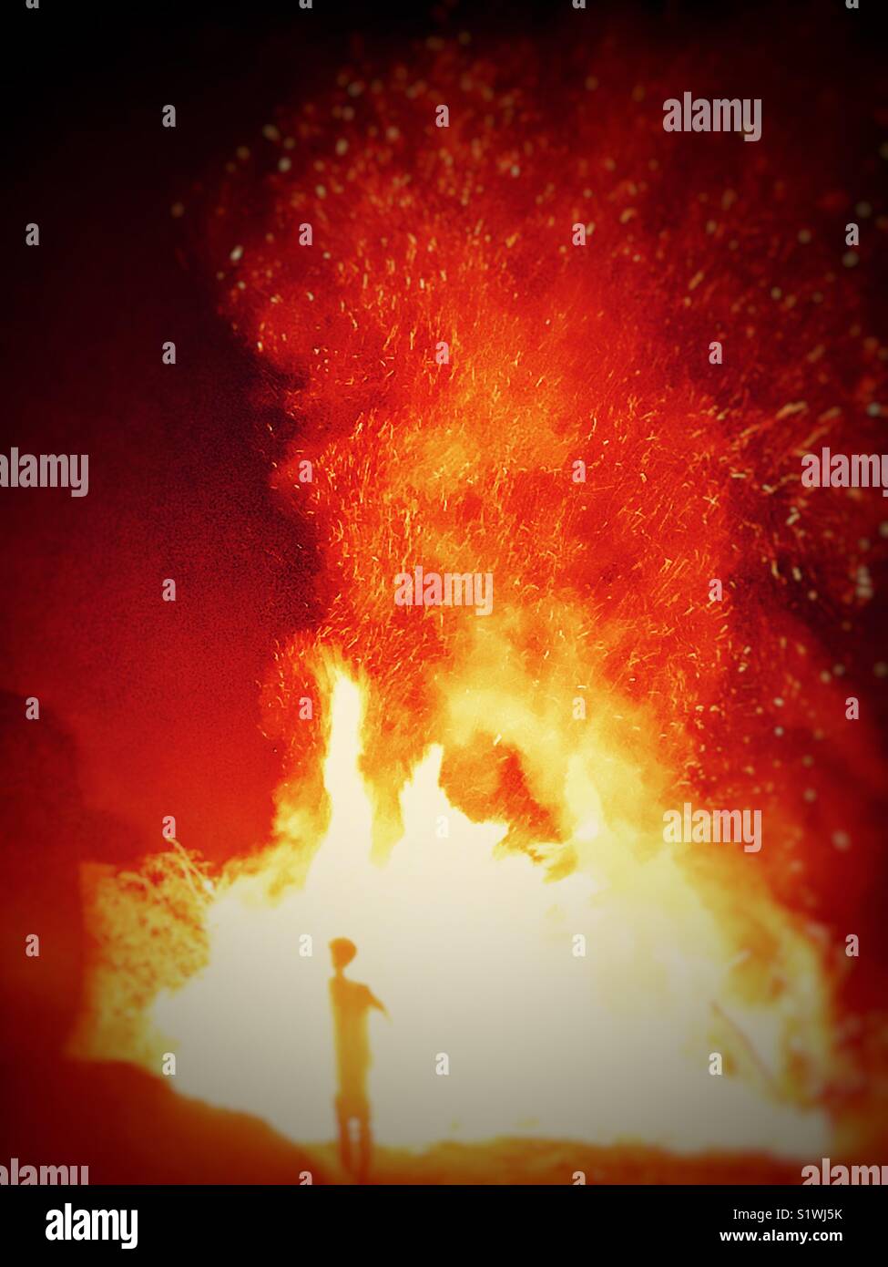 Due persone in piedi di fronte a un inferno infuria il fuoco - Immagine stock catturata con smartphone