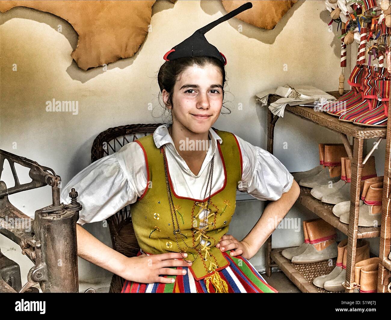 Giovane donna in costume tradizionale, su una bancarella vendendo tradizionale di Madeira stivali e calzature al mercatino di Natale di Funchal, Madeira, Portogallo - Immagine stock catturata con smartphone