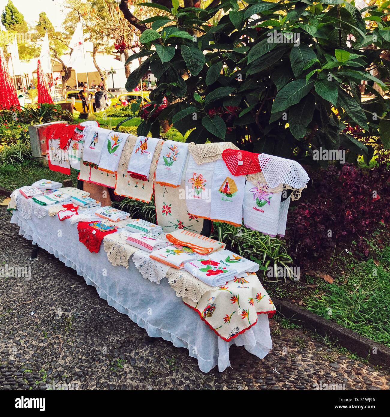 Visualizzazione dei fatti a mano in pizzo di Madeira è venduto da un temporaneo stallo nella giardini comunali a tempo di Natale. Funchal, Madeira, Portogallo - Immagine stock catturata con smartphone