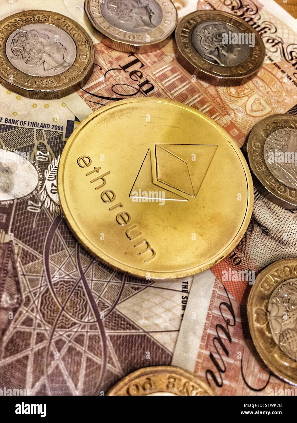 Un Ethereum moneta e British Sterling Pound monete - Immagine stock catturata con smartphone