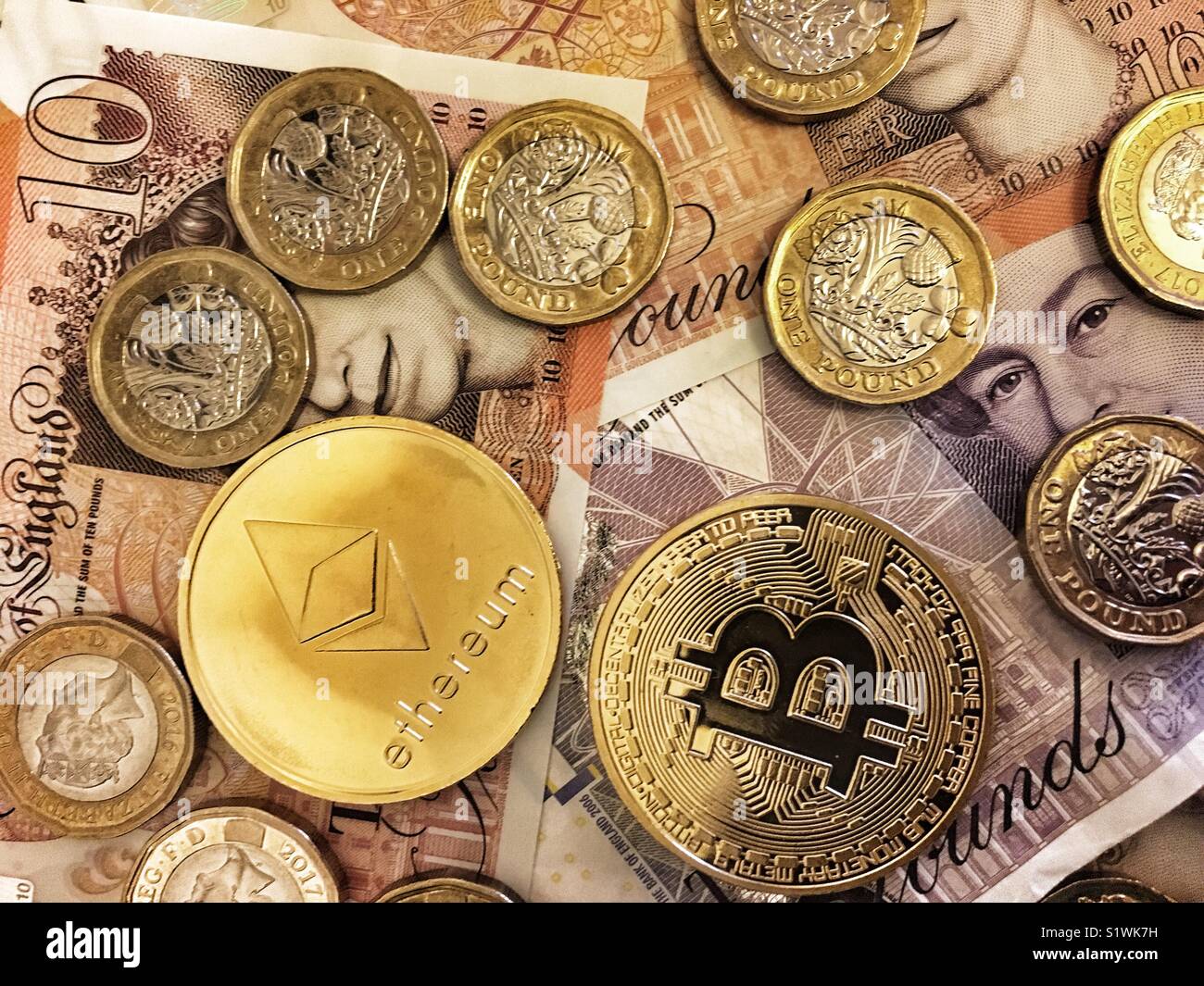 Un Ethereum moneta, un bitcoin e British Sterling Pound monete - Immagine stock catturata con smartphone