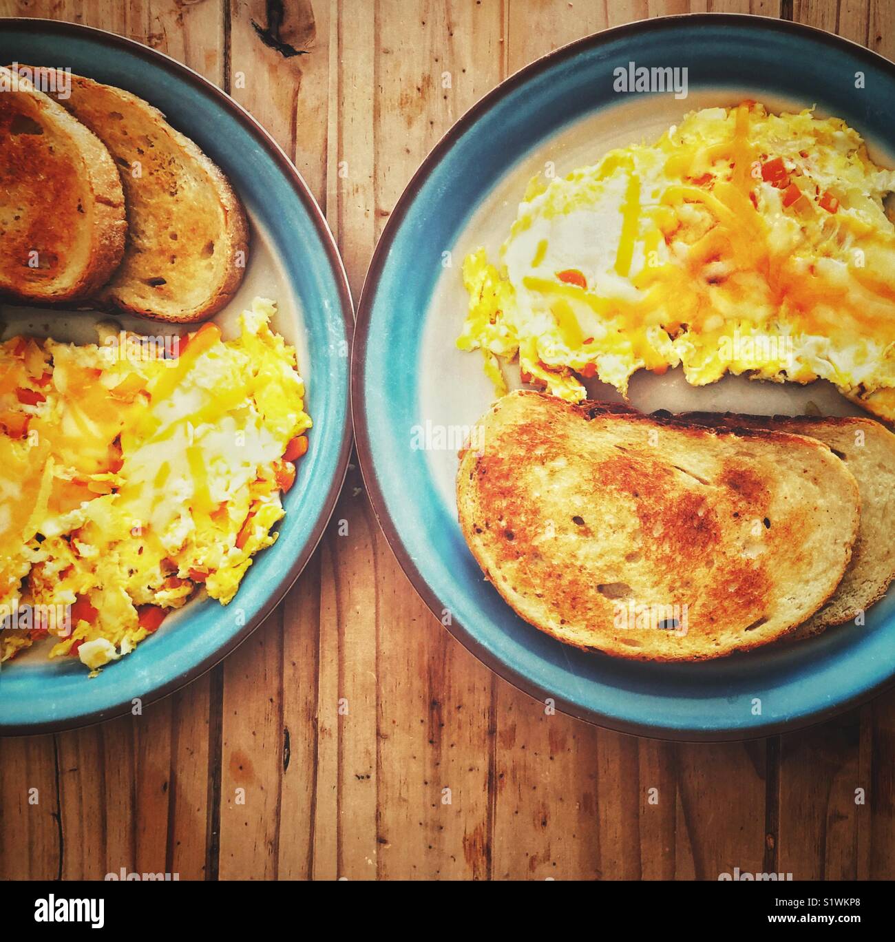 Due piastre di colazione di verdura Frittata con formaggio fuso e la segala toast su un tavolo di legno Foto Stock