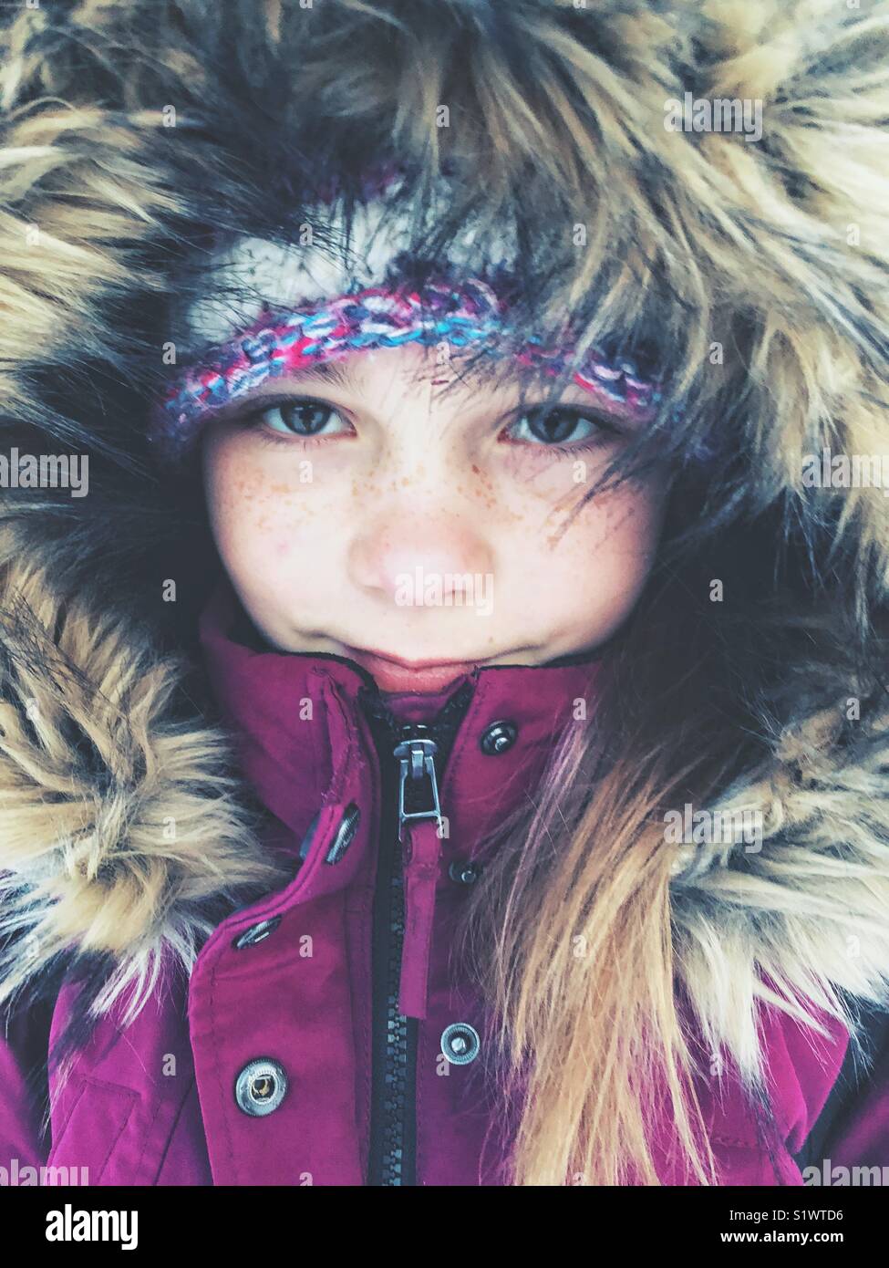 Ritratto di una ragazza che indossa il viola viola giacca invernale con pelliccia di cofano Foto Stock