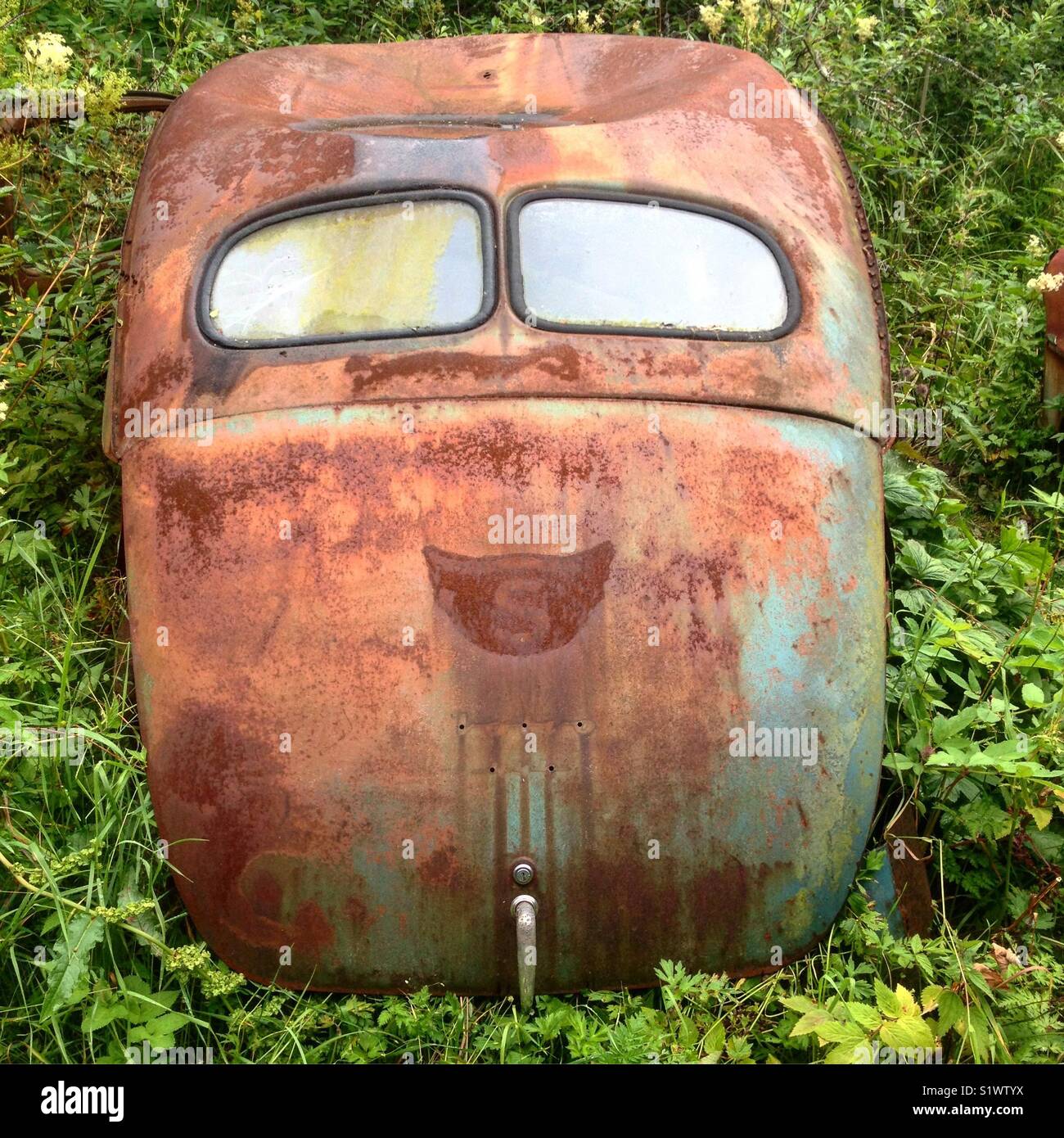 Il finestrino posteriore e il tronco di un vecchio arrugginito Volvo Cars in un cimitero di auto in Båstnäs, Dalsland, Svezia, Scandinavia, Europa - Immagine stock catturata con smartphone