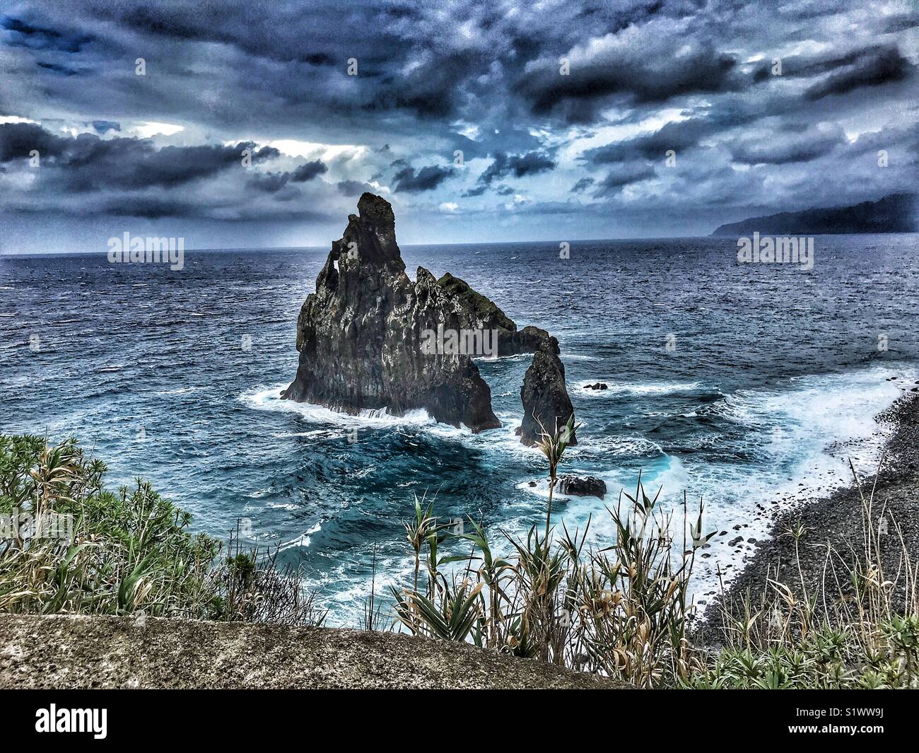 Ilheus de Ribeira de Janela pinnacolo di roccia, con mare mosso e cielo tempestoso, Madeira, Portogallo - Immagine stock catturata con smartphone