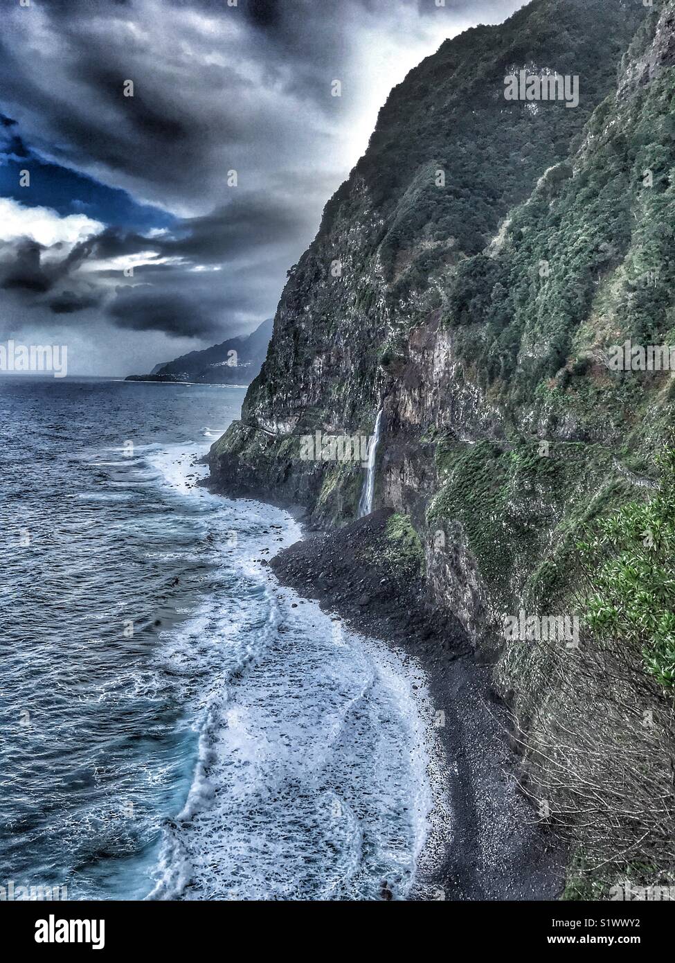 Vista costiera con Bridal Veil Falls e la vecchia strada costiera, chiuse a causa di frane e smottamenti, Madeira, Portogallo - Immagine stock catturata con smartphone