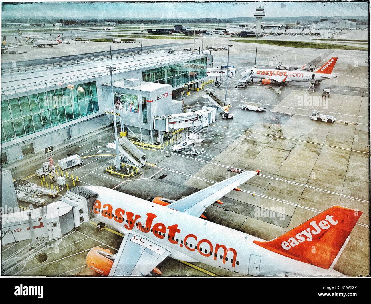 Una veduta aerea di arrivo/partenza gates (airside) @ dall'Aeroporto Gatwick di Londra, Inghilterra. Chiaramente visibili sono 2 EasyJet Airbus. La distanza è la torre di controllo & pista. © COLIN HOSKINS - Immagine stock catturata con smartphone
