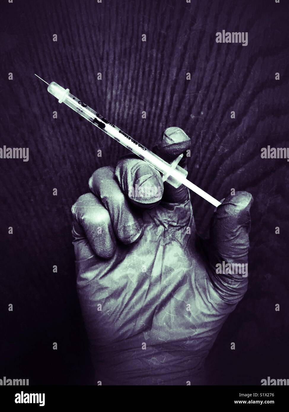 La mano guantata tenendo una siringa - Immagine stock catturata con smartphone