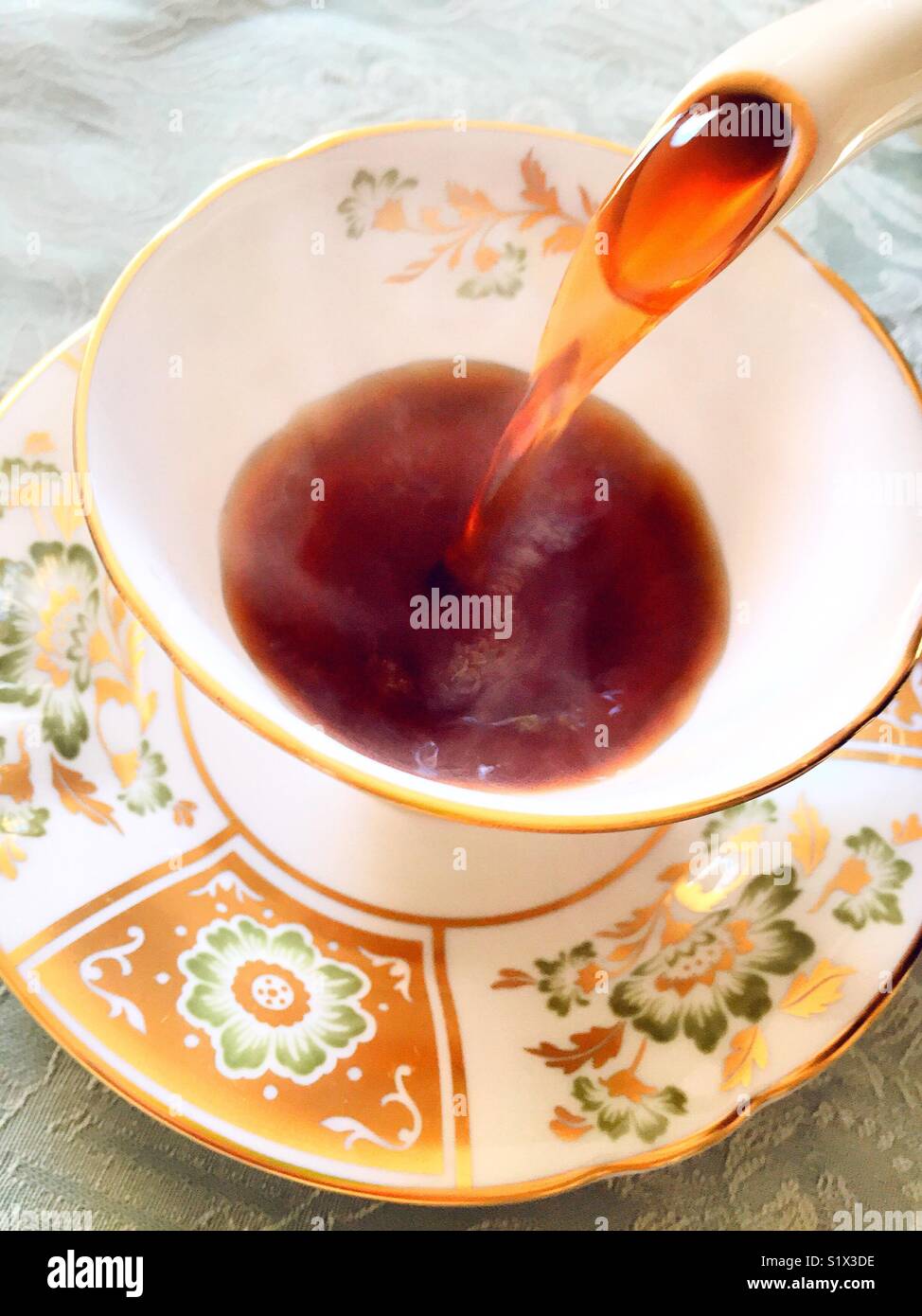 Versare il caffè in una tazza inglese di Royal Crown Derby china. - Immagine stock catturata con smartphone
