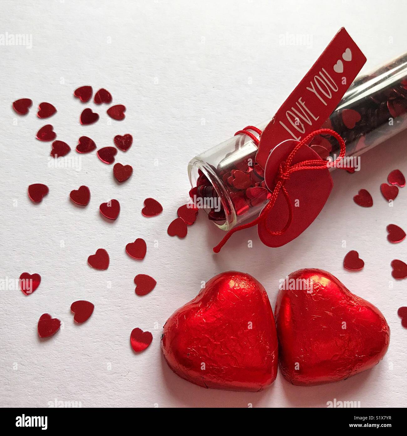 Il giorno di San Valentino, a forma di cuore e spruzza due Cuori di cioccolato avvolto in rosso, lamina piana fotografia laici, ad alto angolo di visione - Immagine stock catturata con smartphone