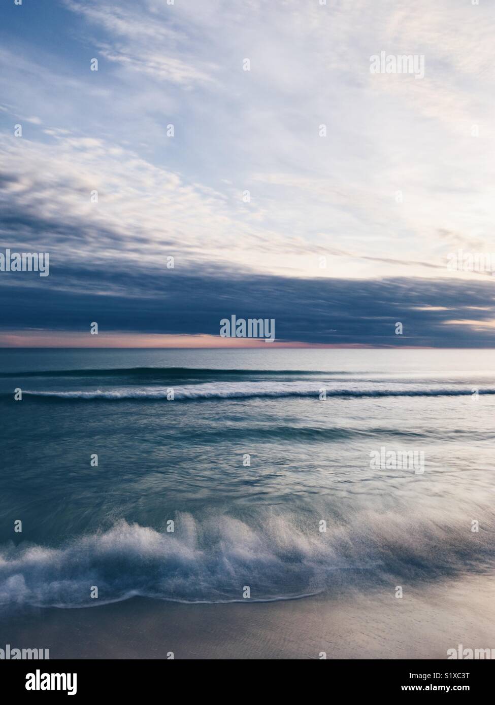 Una lunga esposizione delle onde che lambiscono su una spiaggia in Florida sulla costa del Golfo del Messico. - Immagine stock catturata con smartphone