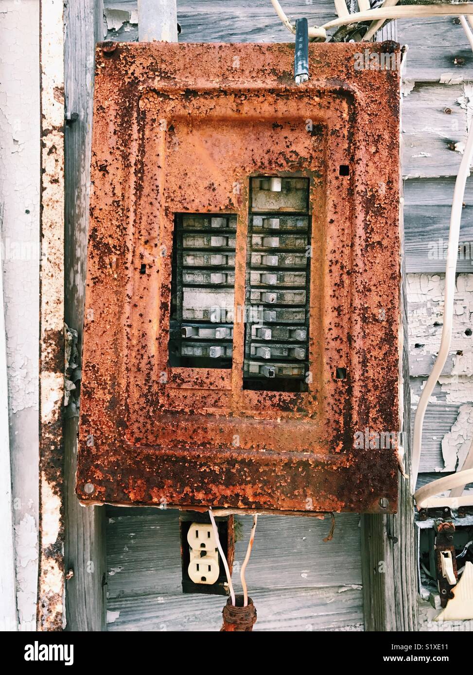Rusty il vecchio interruttore elettrico box sulla parte esterna di un abbandonato casa sulla spiaggia in Florida, Stati Uniti d'America. Foto Stock